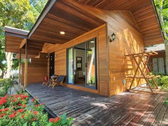 婆罗洲马布度假村带木平台和红花的木结构小屋（占位图，换图时需重新核对）
