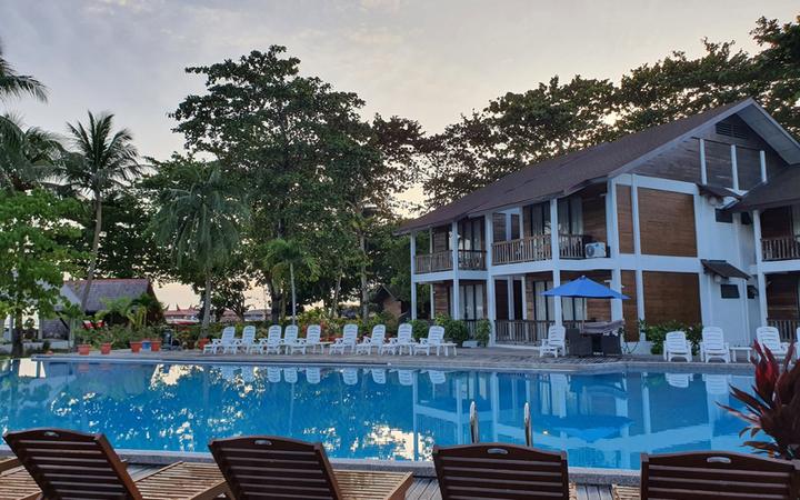 Swimming pool with sun loungers in front of a two-storey villa building at Borneo Divers Mabul Resort (placeholder, to recheck when the photo is replaced)