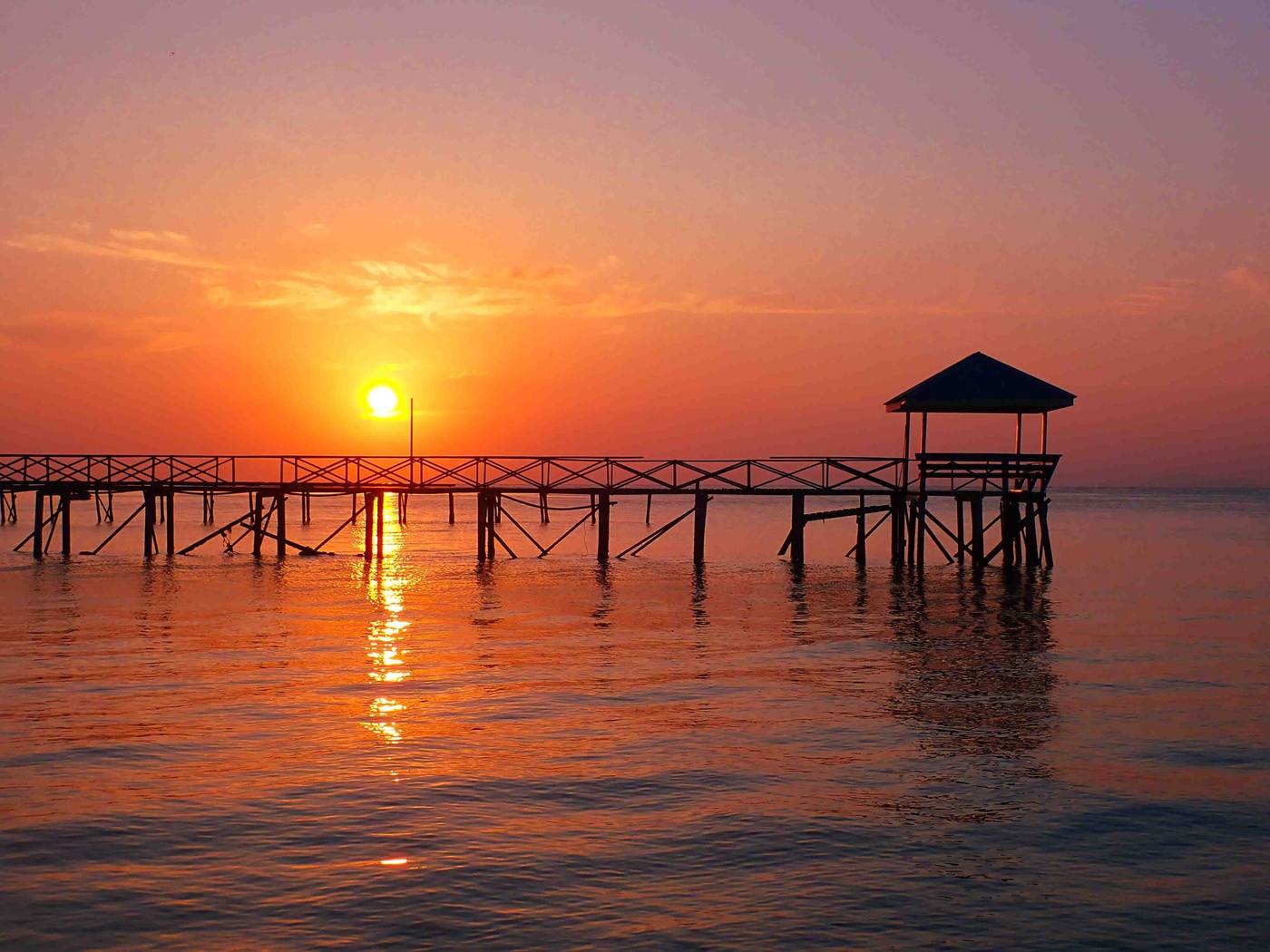 Sunset over the sea with a long wooden jetty and a small gazebo at its end (placeholder, to recheck when the photo is replaced)
