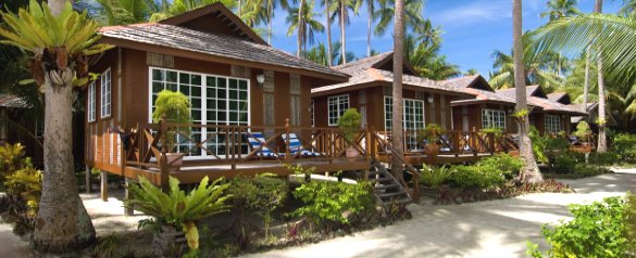 Timber chalets with verandahs and sun loungers under coconut palms at Sipadan-Mabul Resort (placeholder, to recheck when the photo is replaced)